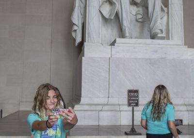 在华盛顿林肯纪念堂，两名学生站在亚伯拉罕·林肯雕像前.C.